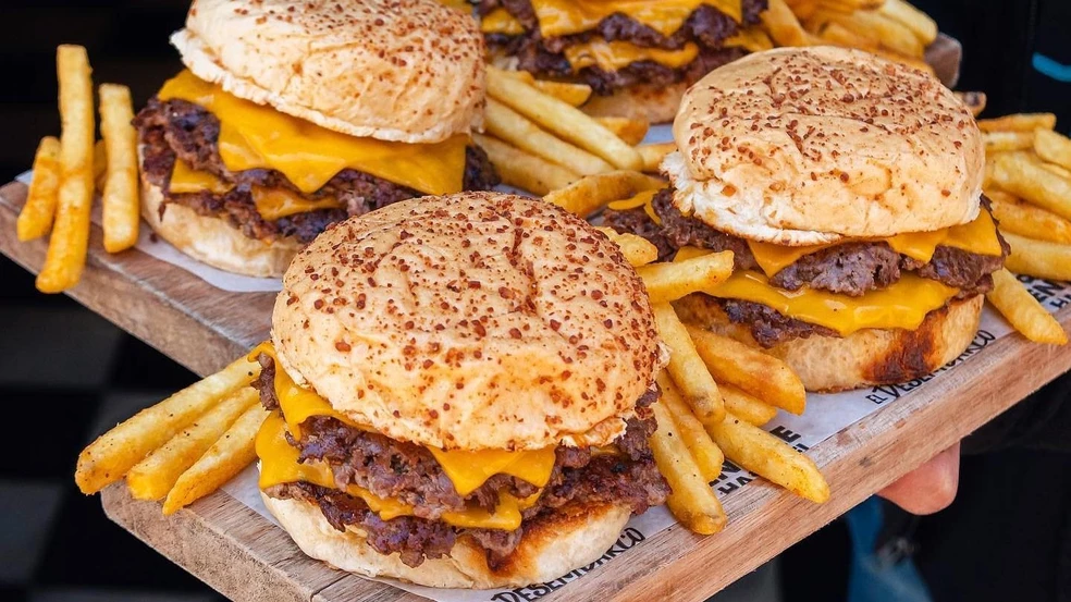 Logotipo de la Cámara de Hamburgueseros de Rosario y hamburguesa sobre fondo neutro.