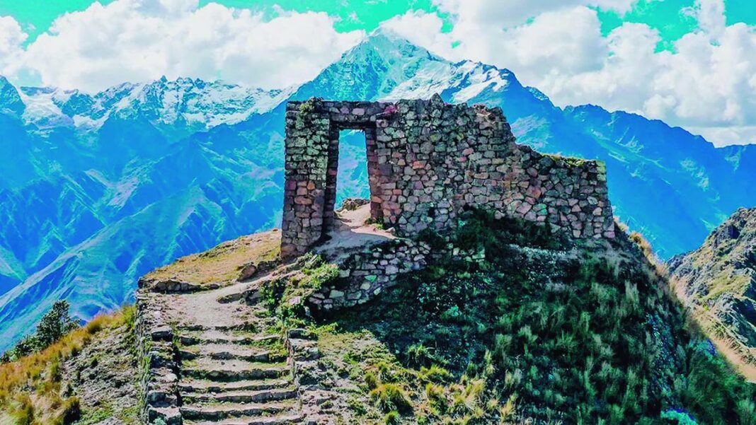 Vista del sendero del Camino del Inca con montañas y ruinas al fondo.