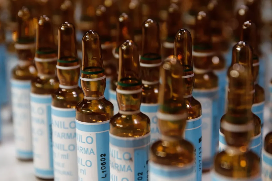 Ilustración de ampollas médicas y un documento oficial con el sello de la Anmat.