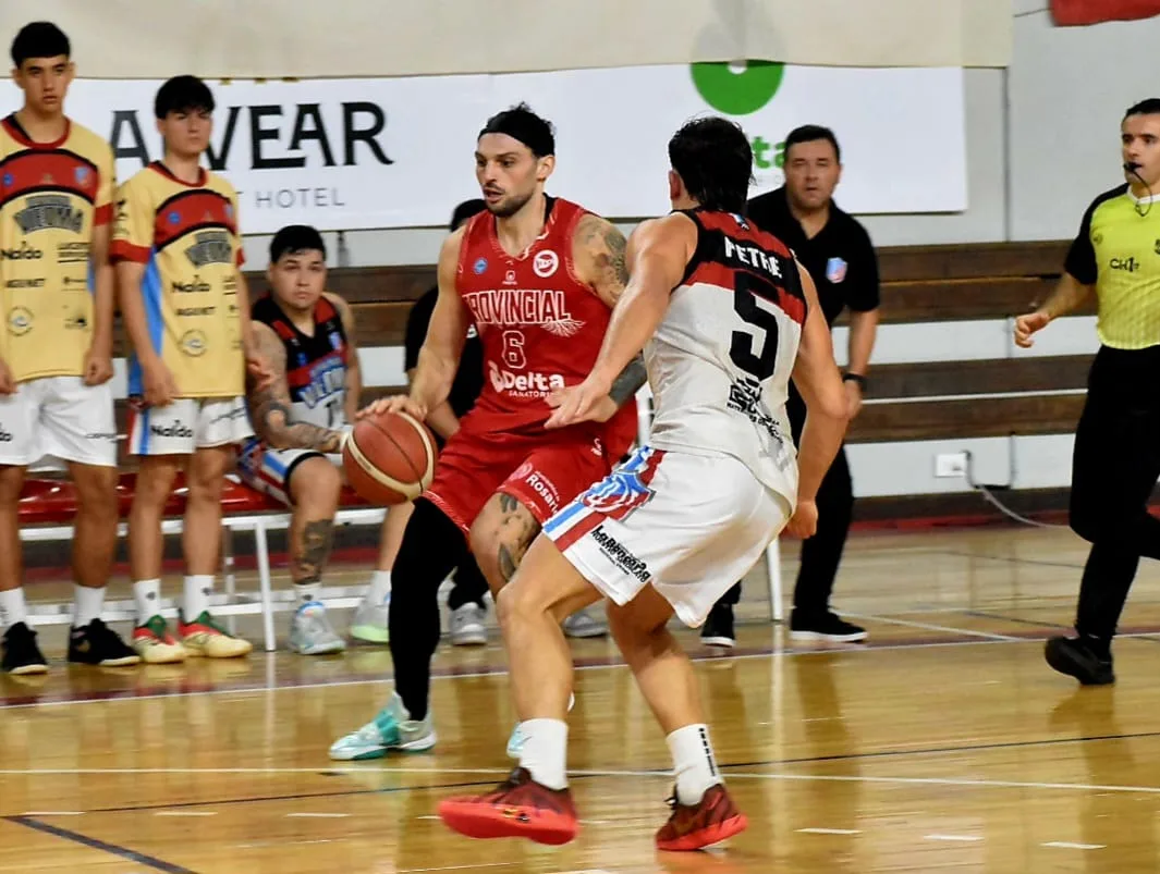 Jugadores de Provincial y Deportivo Viedma en acción durante un partido de básquet.