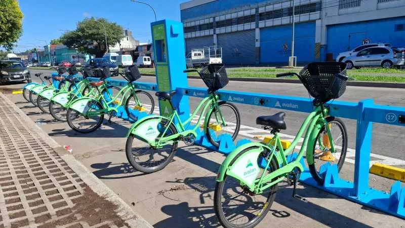 Personas utilizando bicicletas públicas del sistema Mi bici tu bici en una estación de Rosario.