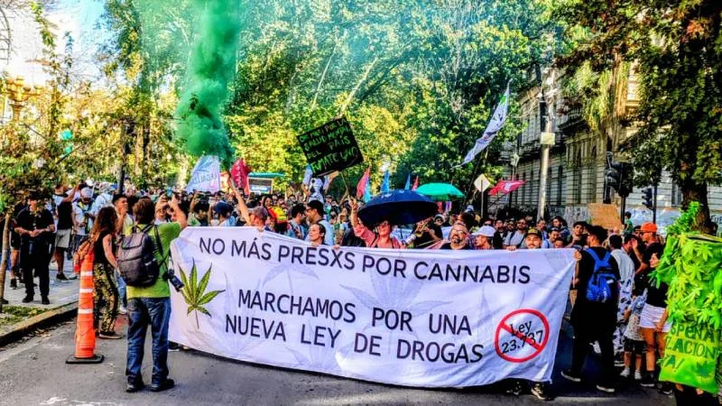 Personas marchando con carteles y banderas en la Marcha Mundial de la Marihuana en Rosario