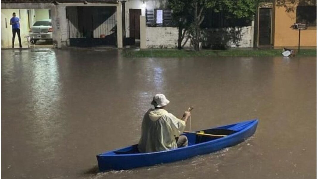 Calle anegada y vehículo transitando con dificultad por el agua en una localidad del norte de Santa Fe tras el temporal.