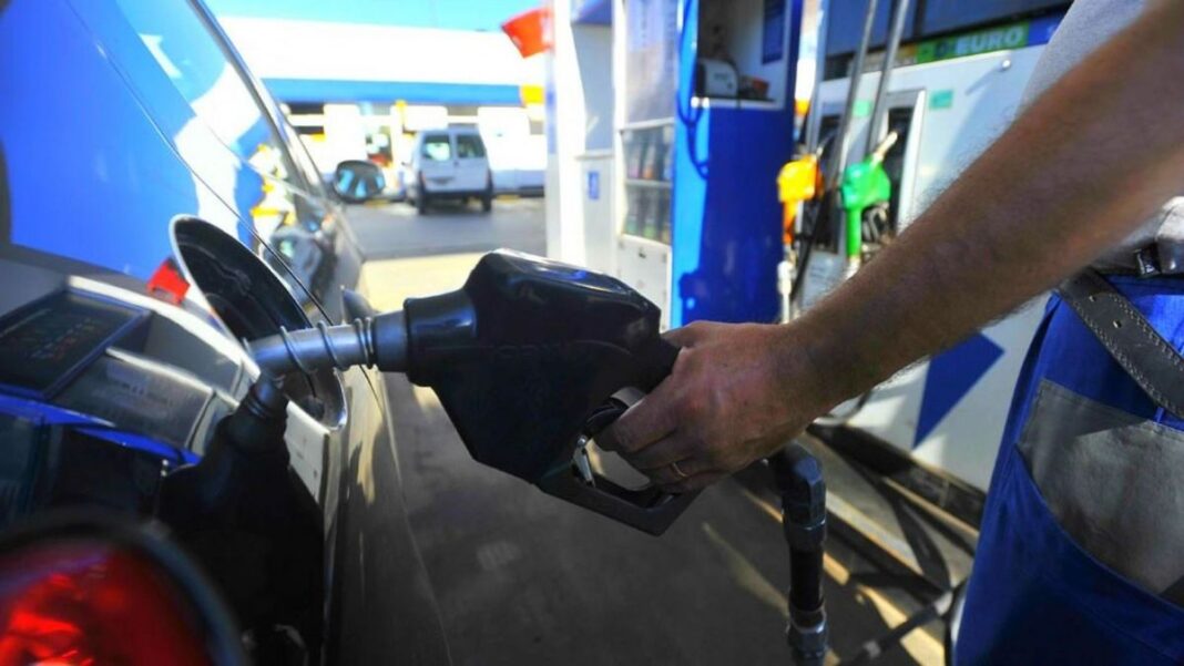Surtidor de combustible con cartel de precios en una estación de servicio