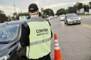 Tránsito vehicular en la ciudad de Santa Fe con semáforo y cartel de infracción