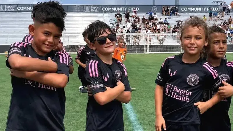 Ciro Messi celebrando un gol con lentes de sol en un partido de fútbol juvenil