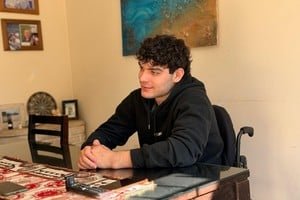 Joaquín Martínez sentado en silla de ruedas en el comedor de su hogar familiar en barrio María Selva