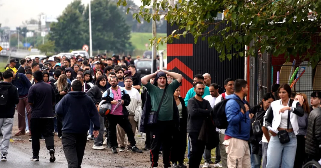 Fila de personas en la entrada del frigorífico Cabaña Don Theo en Moreno