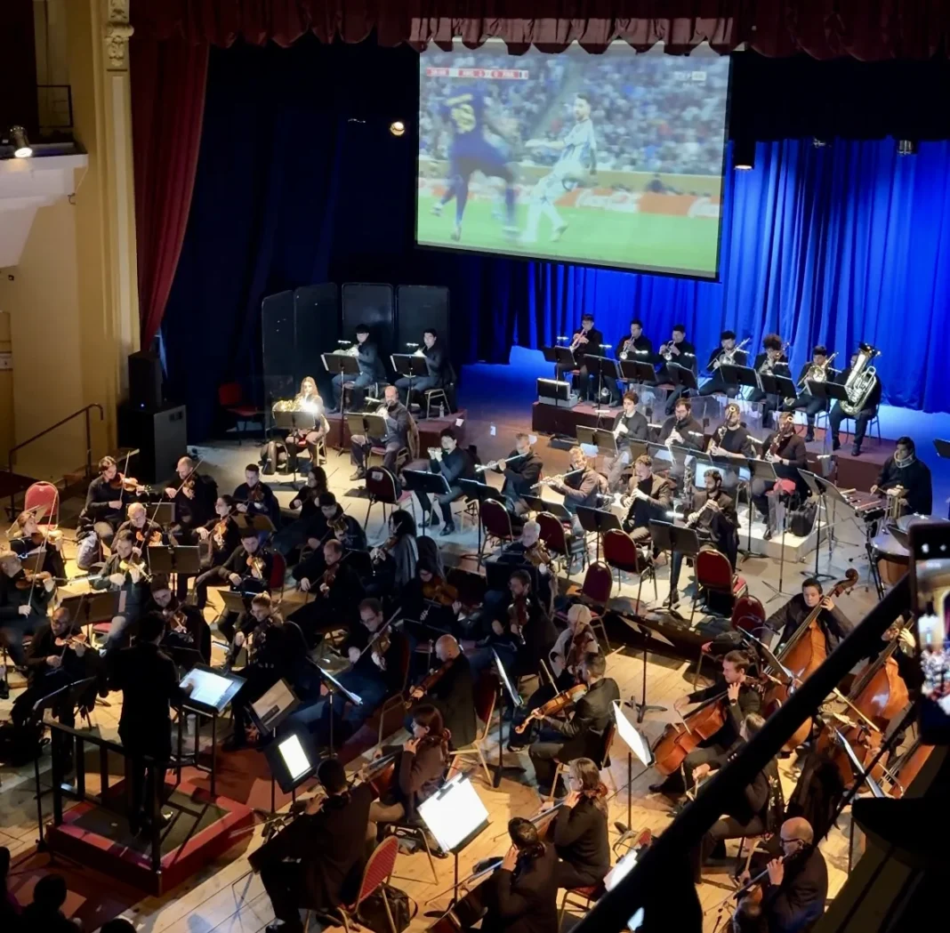 Escenario del Teatro El Círculo de Rosario con la Orquesta Sinfónica y pantalla gigante durante el espectáculo La Scaloneta Sinfónica