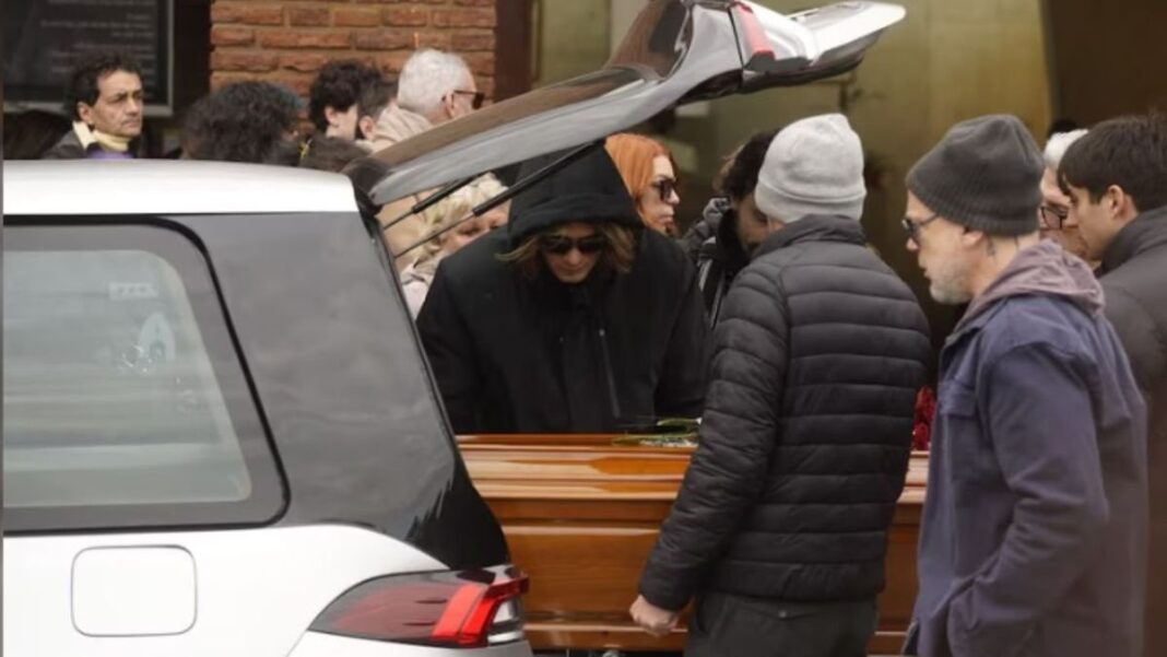 Féretro de Ernestina Pais cubierto con flores rojas en el Cementerio de la Chacarita