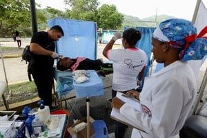Personas usando teléfonos y computadoras para buscar desaparecidos tras sismos en Venezuela