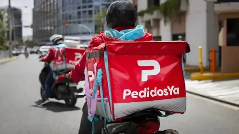 Repartidor de delivery en moto con mochila térmica en la calle