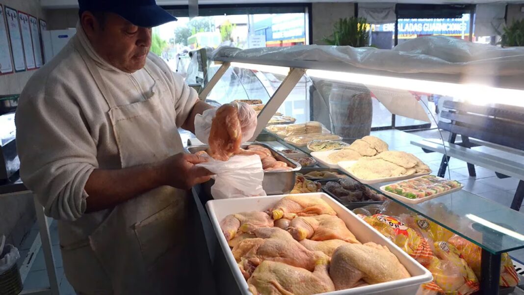 Pollo crudo en bandeja sobre mesa de cocina
