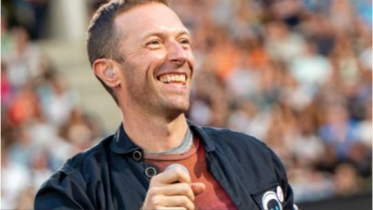 Chris Martin cantando junto a un músico callejero en Trafalgar Square