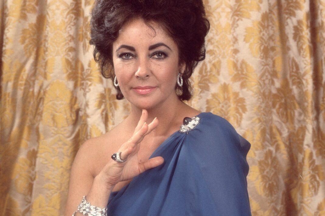 Elizabeth Taylor sonriendo en una alfombra roja
