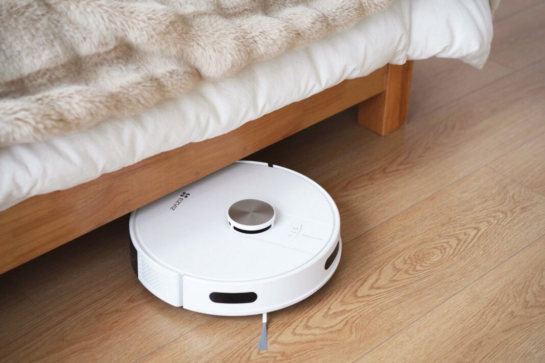 Aspiradora robot Ezviz RE4 en color blanco sobre piso de madera