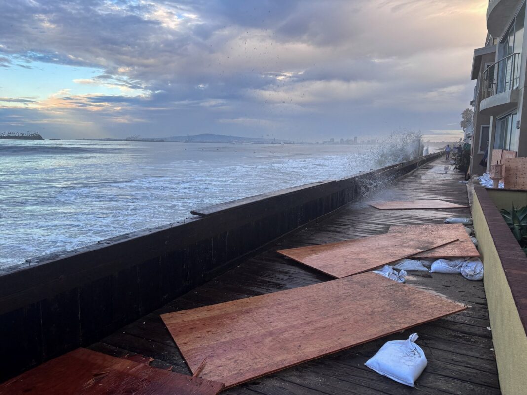 Olas golpean el paseo marítimo de madera en Long Beach