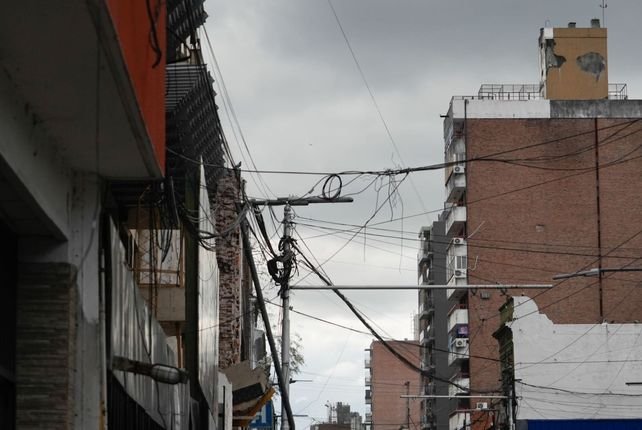 Postes con cables aéreos enredados en la vía pública de Santa Fe